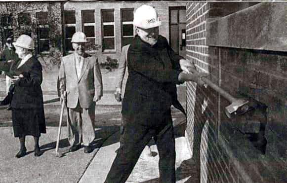 Father Joseph Grosko takes the first
swing during the groundbreaking
ceremony for the Creedmoor Court
Senior Apartments - October 29, 2003.