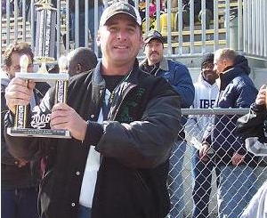 Head Coach Mike Manuel holds
the championship trophy. The kids
earned it, but they couldn't have
done it without the dedication of
the coaching staff and Coach Mike.
