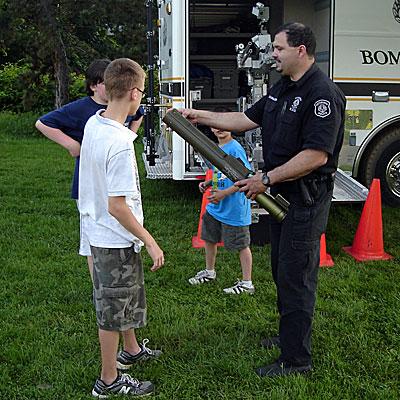 Officer Schrader shows the kids how
to operate the portable rocket launcher.