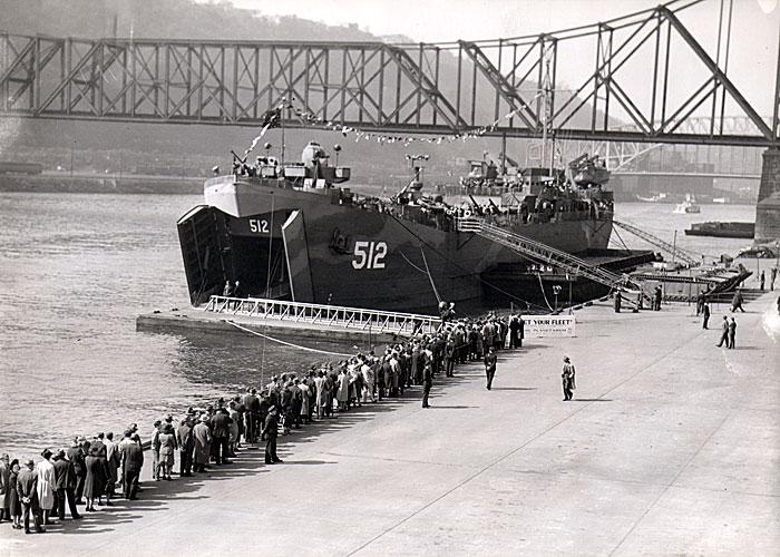 LST-512 moored on the banks of
the Monongahela River in Pittsburgh.
A long line of visitors awaits the
chance to view the war exhibits.