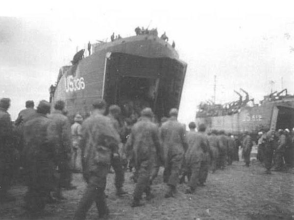 German POWs are loaded aboard
LST-512 (right) the Normandy beach.